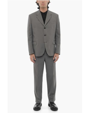 Traje gris de 3 botones, corte entallado, solapa con muesca y aberturas laterales