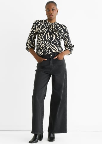 Blusa de satén con cuello alto y estampado animal negro