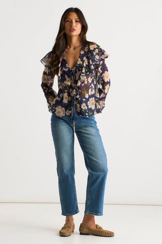Blusa azul marino con volantes en la parte delantera y estampado floral