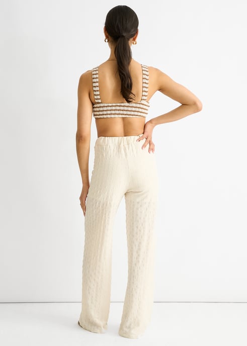 Pantalones acampanados con cintura elástica y textura beige - Image 4